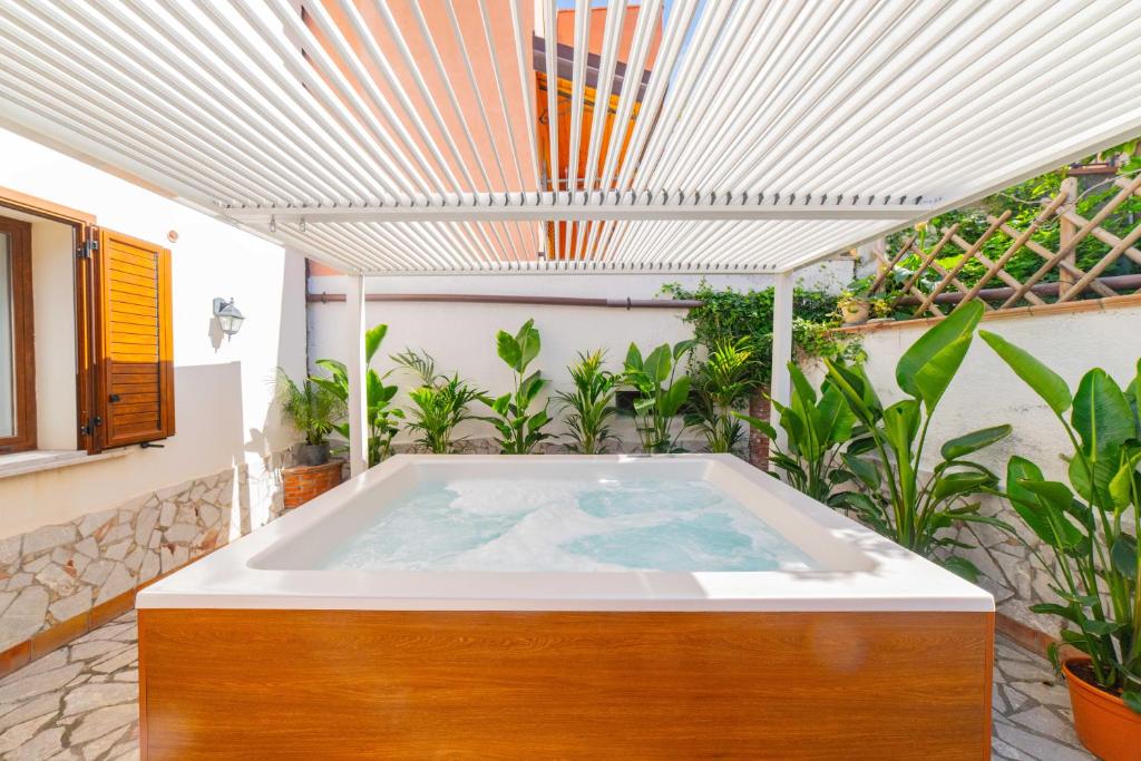 a hot tub on a patio with plants at Taormina Sea View Apartment in Taormina