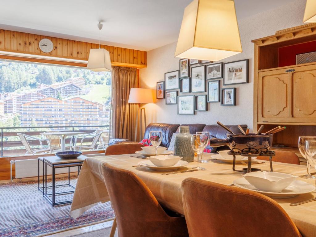 ein Esszimmer mit Tisch und Stühlen und einer Couch in der Unterkunft Apartment Rossignol C4 by Interhome in Nendaz