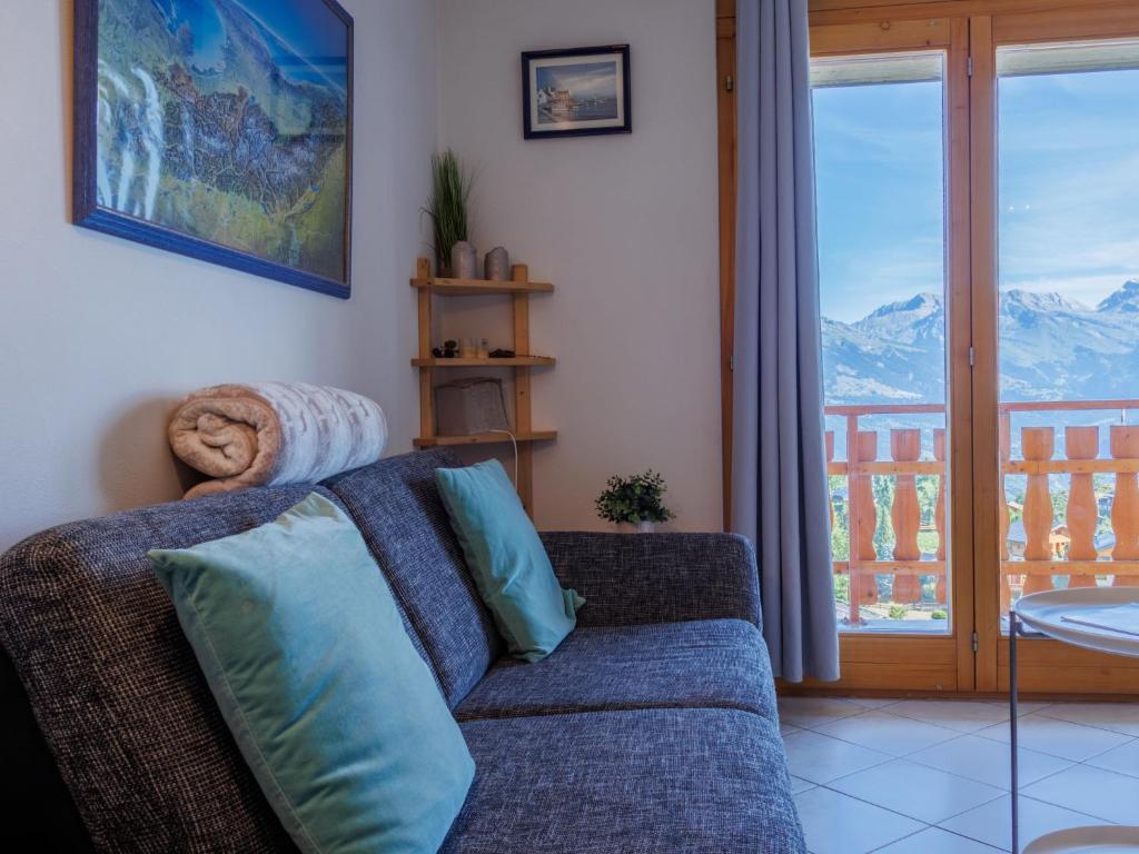 a living room with a couch and a balcony at Apartment Grand Panorama A11 by Interhome in Nendaz