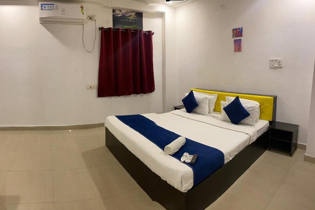 a bedroom with a bed with blue and white pillows at Fortune Heights in Hyderabad
