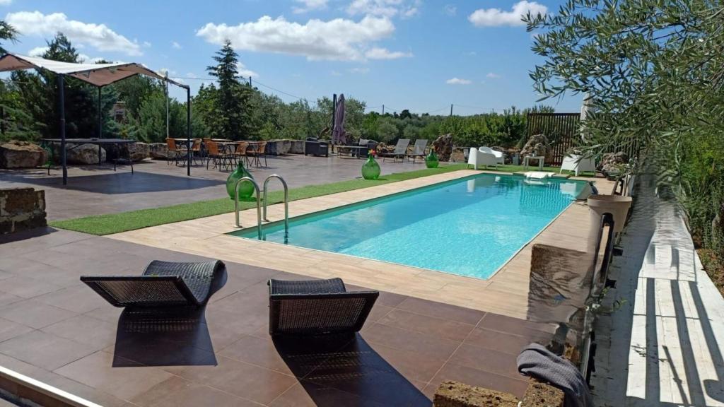 a swimming pool in a yard with two chairs at Borgo Incanto in Acquaviva delle Fonti