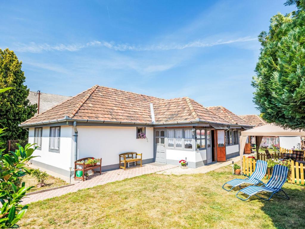 a house with two lawn chairs in the yard at Holiday Home Sunny by Interhome in Balatonőszöd