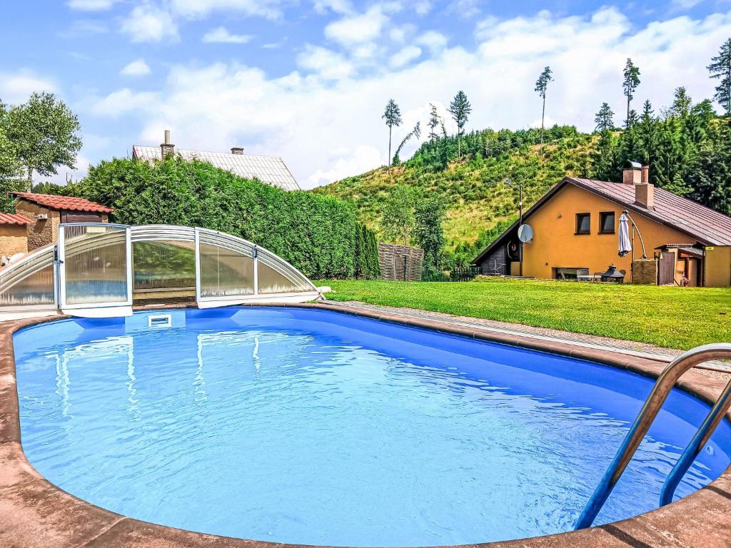 a swimming pool with a metal bridge over it at Holiday Home Dolníky u Trutnova by Interhome in Oblanov