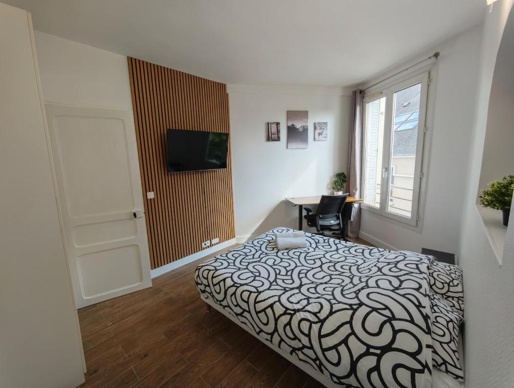 une chambre avec un lit, un bureau et une fenêtre dans l'établissement Paris Cozy Studio - 15 Min Paris, à Aulnay-sous-Bois