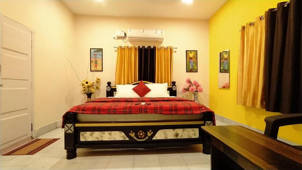 a bedroom with a bed with a red blanket at Kushi Home Stay in Visakhapatnam