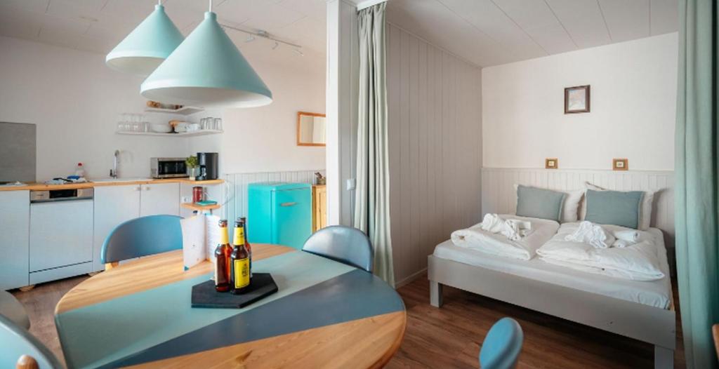 a small apartment with a bed and a table and chairs at Strandkoje - Landhaus in Neustadt in Holstein