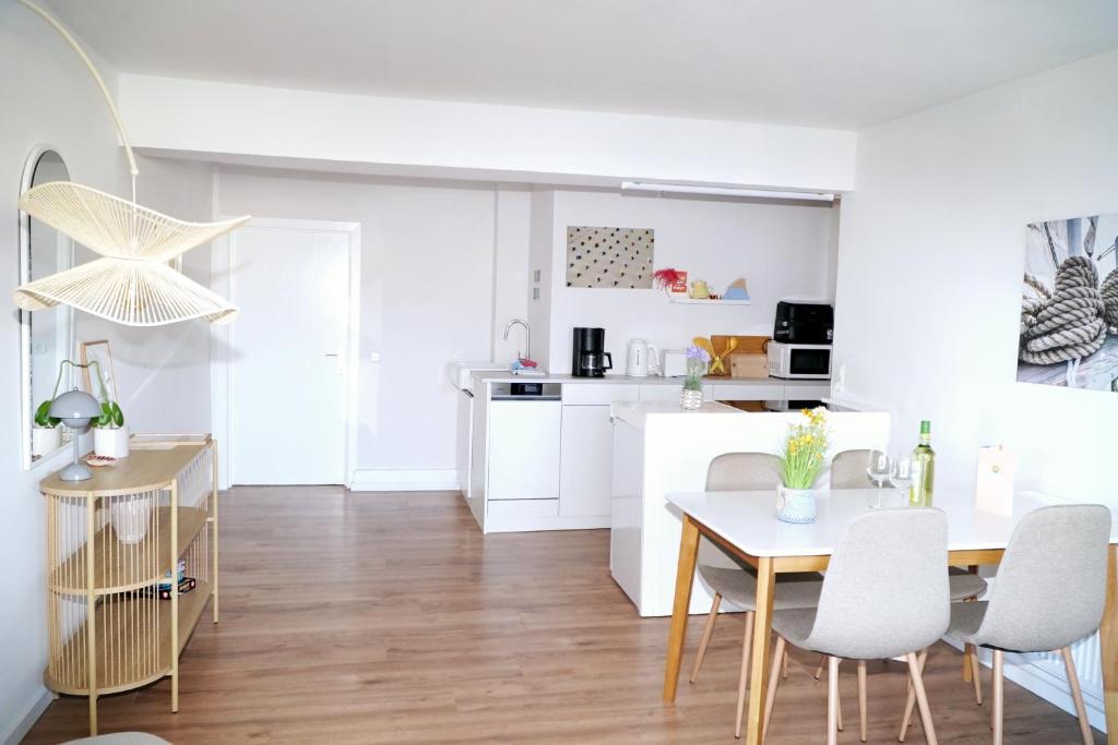 a kitchen and dining room with a table and chairs at Strandkoje - Leuchtturm in Neustadt in Holstein