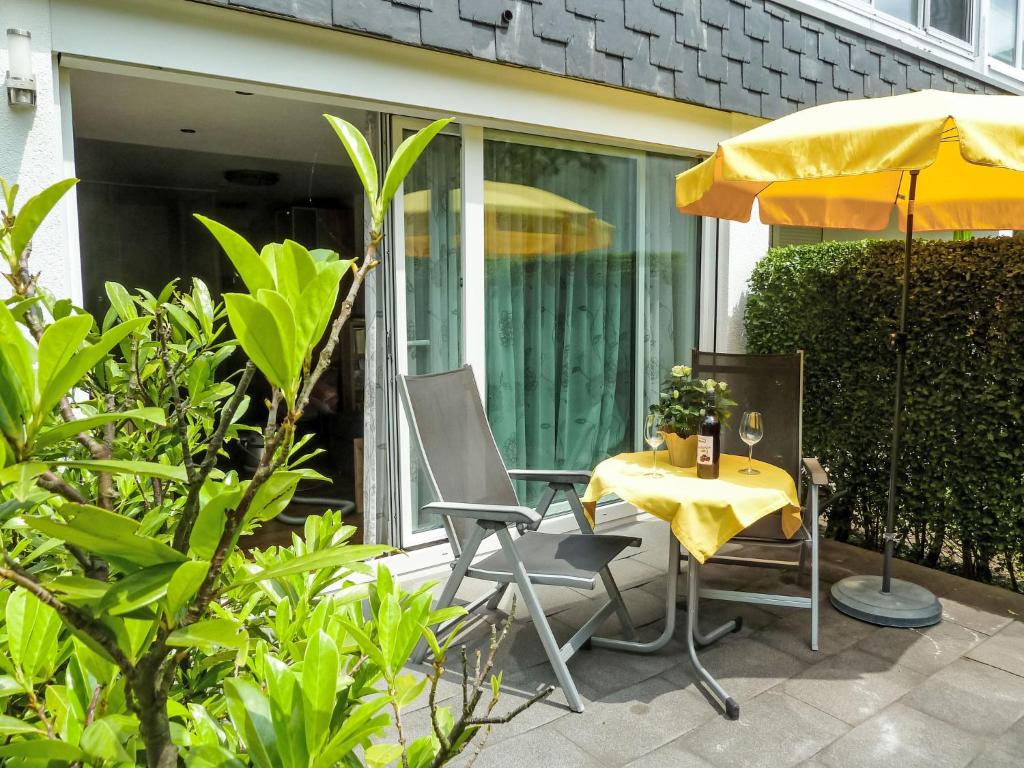 a patio with a table and a yellow umbrella at Apartment Seestraße 60 by Interhome in Döbriach