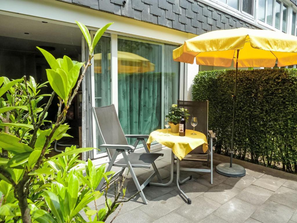 a yellow umbrella and a table and chairs on a patio at Apartment Seestraße 60 by Interhome in Döbriach