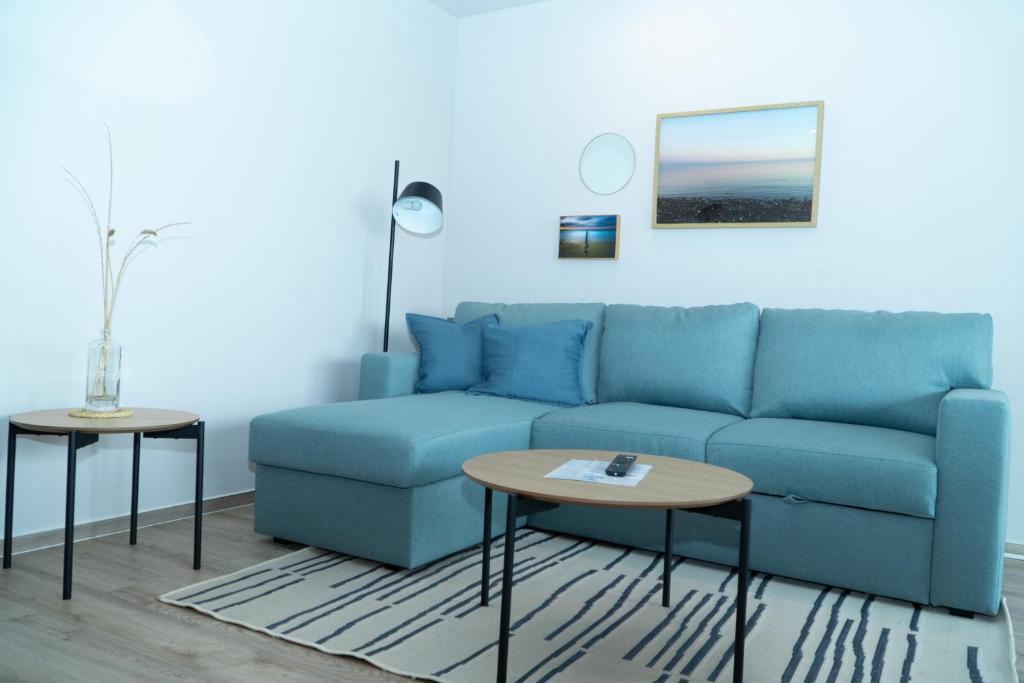 a blue couch in a living room with a table at Strandkoje - Strandmuschel in Neustadt in Holstein