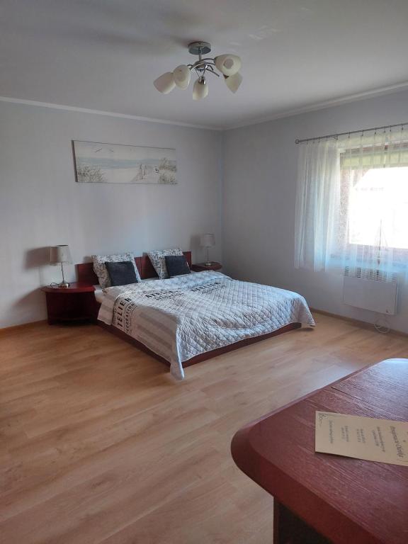 a bedroom with a bed and a ceiling fan at Pensjonat Oleńka in Ustka