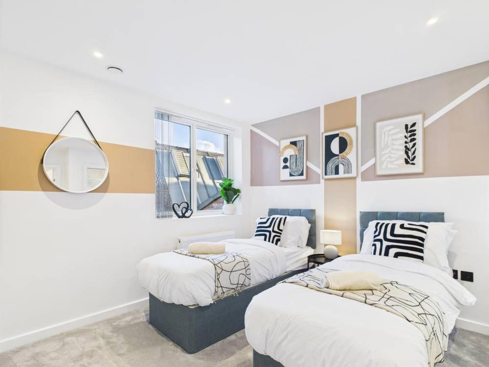 a bedroom with two beds and a mirror at Stylish 2 Bedroom Flat | Sleeps 4 | in Brent Station