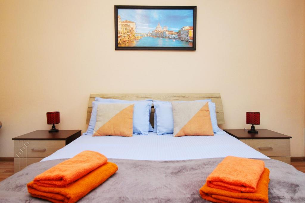 a bedroom with a bed with orange towels on it at Меркур возле Аэропорта in Almaty