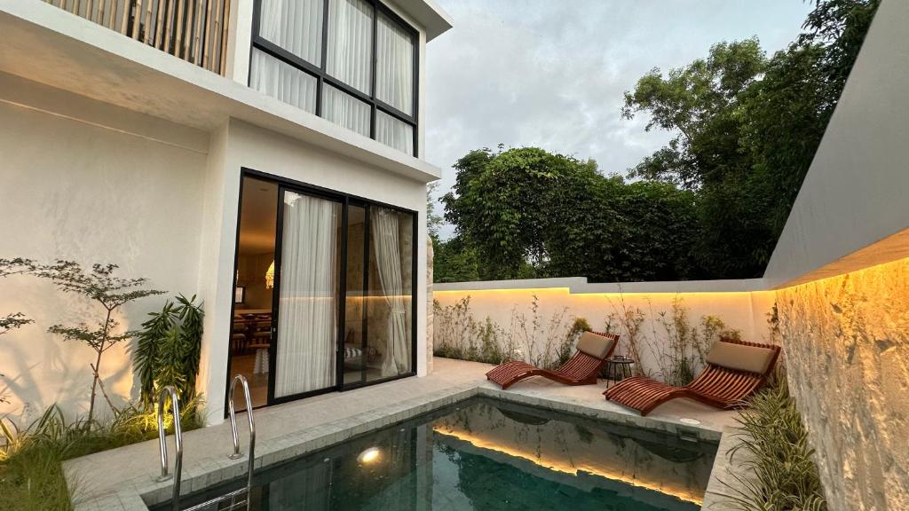 a house with a swimming pool next to a building at Dreamland View Villa #3 with Pool in Uluwatu