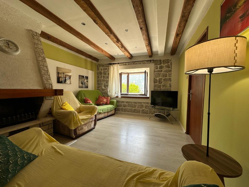 a living room with a couch and a tv at Garden Vista Stone House in Kotor