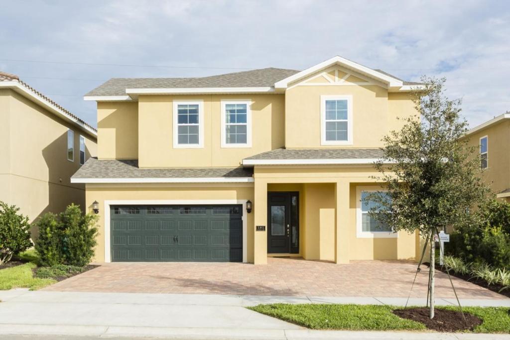 a yellow house with a garage at Villa EC036 in Orlando