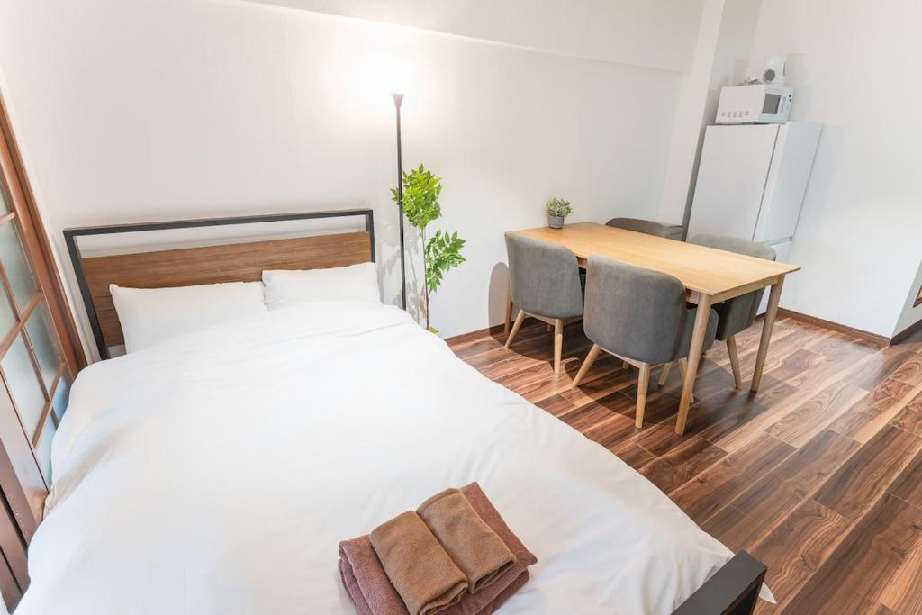a bedroom with a bed and a table and a dining room at Shibuya E-address 205 in Tokyo