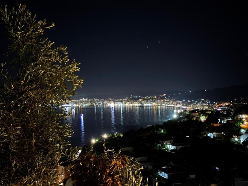 a view of the water at night with a city at Mesaiz in Vlorë