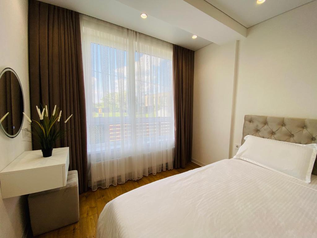 ein Schlafzimmer mit einem weißen Bett und einem großen Fenster in der Unterkunft Apartament Chisinau in Chişinău