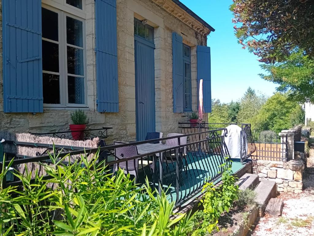 a house with blue shutters and a fence at Le Petit Figuier in Villefranche-du-Périgord