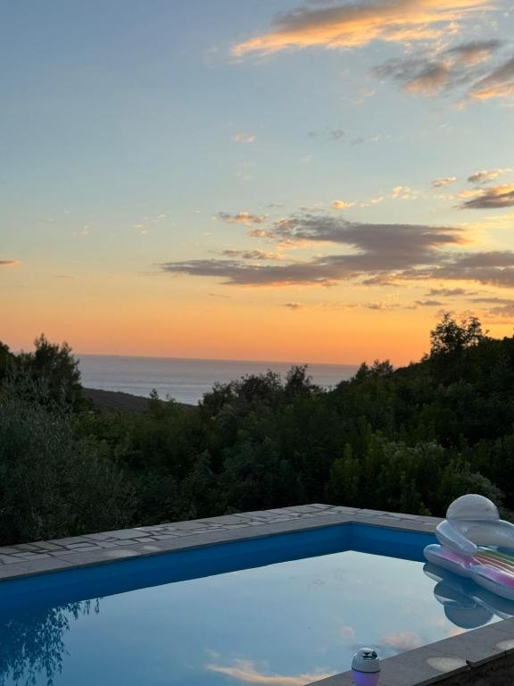 a pool with a view of the ocean at sunset at Sun Place Bigova in Bigova