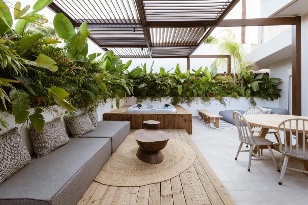 un patio con plantas, mesa y sillas en HUGme Suite, en Kalithies