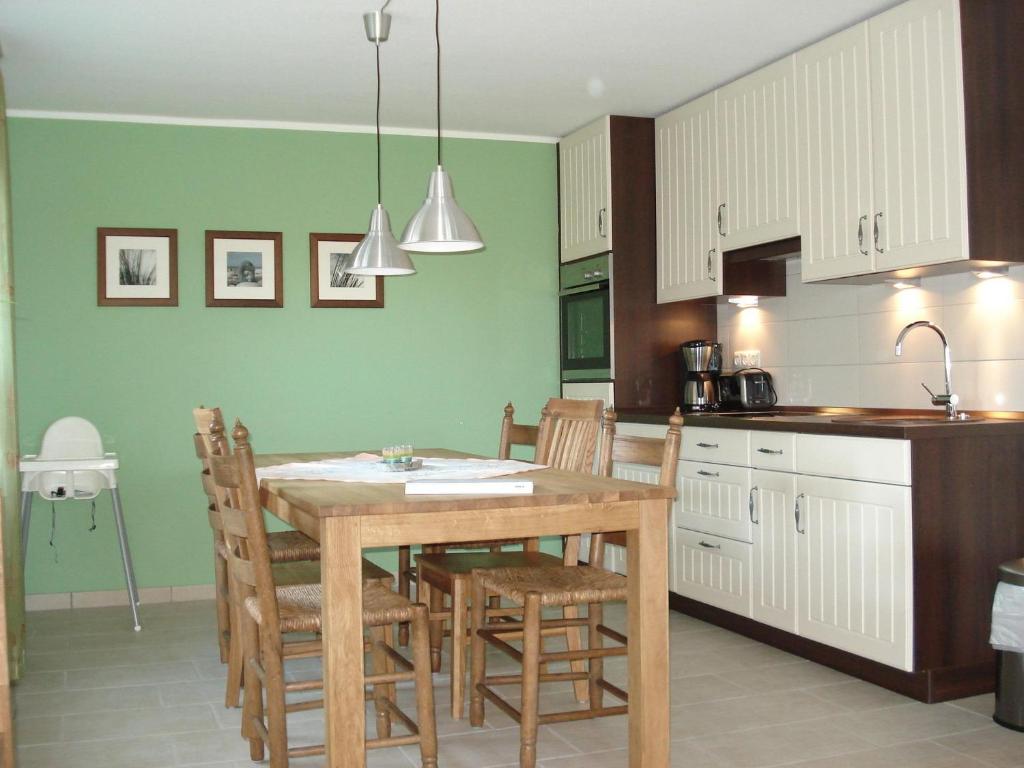 a kitchen with a table and chairs in a room at "CASA-MARE" Fehmarn in Wulfen auf Fehmarn