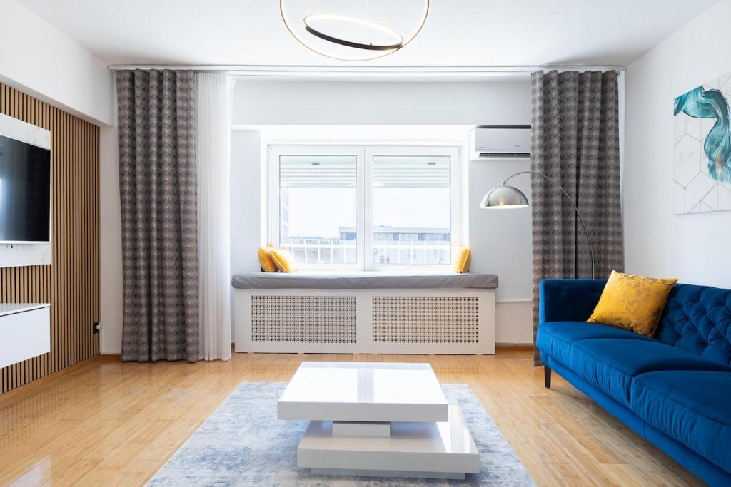 a living room with a blue couch and a window at 1001 Central Riverside Flat in Bucharest