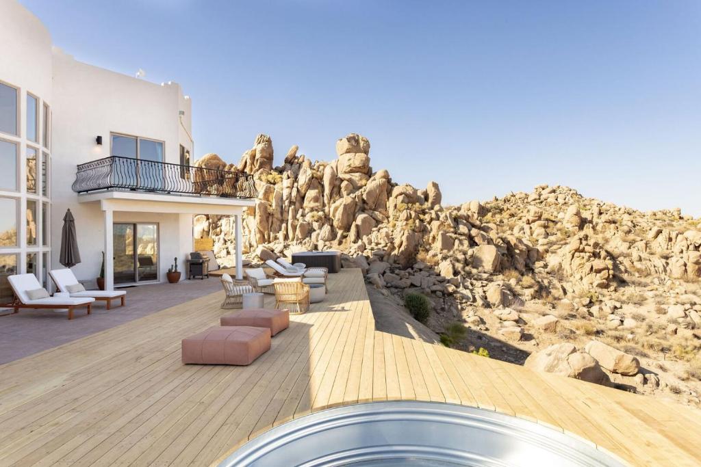 a house with a rock wall at Casa Blanca by Fieldtrip Boulder Estate with Hot Tub Soaking Pool Outdoor Shower in Yucca Valley