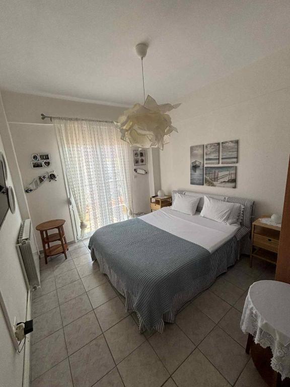 une chambre avec un lit et une grande fenêtre dans l'établissement Villa Dina, à Paralia Dionisiou