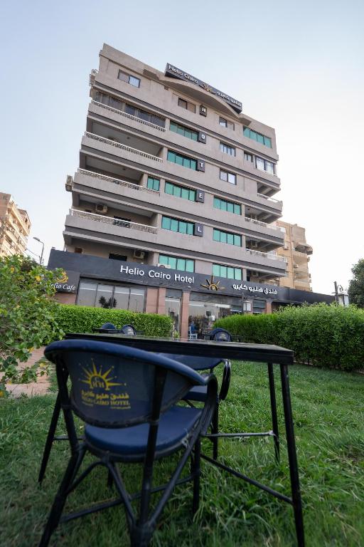 a table in the grass in front of a building at Helio Cairo Hotel in Cairo