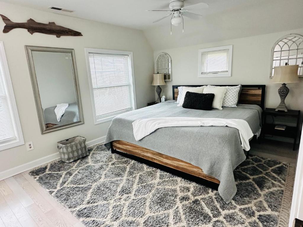 a bedroom with a bed and a fan and windows at coastal and cozy beach stay, pet friendly in Milford