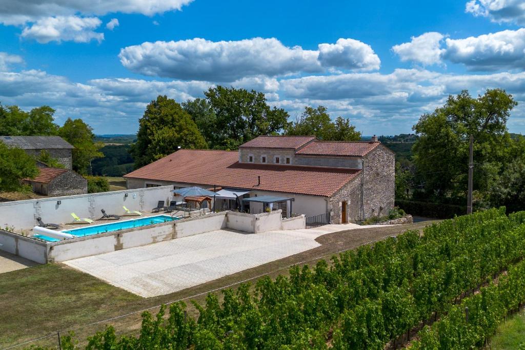 une vue aérienne d'une maison avec piscine dans l'établissement Le Chai Villa, à Thénac
