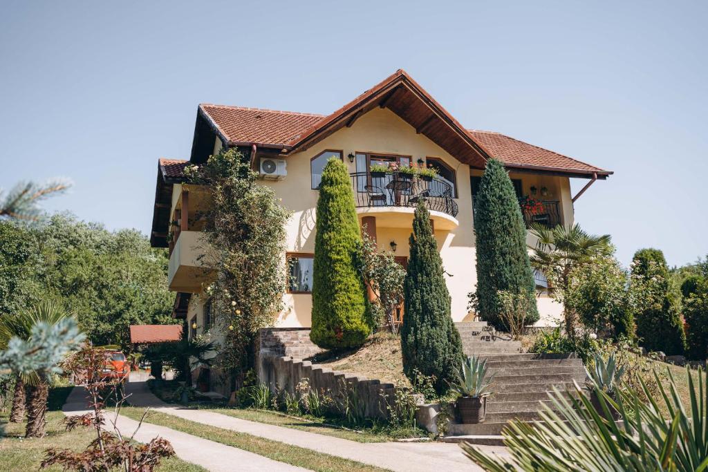 a house with trees in front of it at Casa cu Palmieri in Călimăneşti