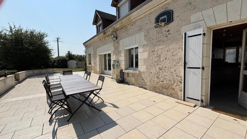 a table and chairs on a patio next to a building at Maison familiale à la campagne in Vallères
