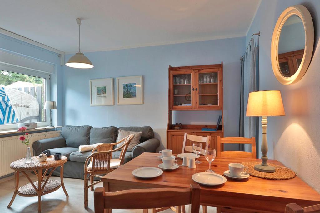 a living room with a table and a couch at Bungalow Paul in Nienhagen