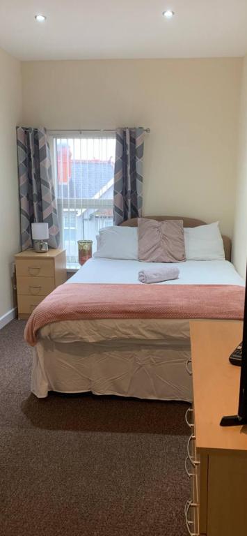 a bedroom with a large bed and a window at 34 - Room 5 - Uplands in Swansea