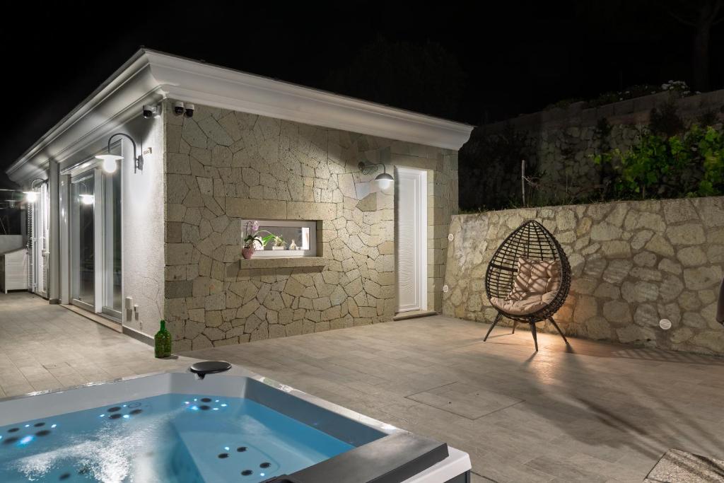 a jacuzzi tub in a patio with a chair at Maison Margot in Forio d'Ischia