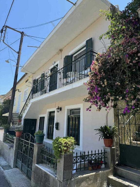 a white house with balconies and flowers at Barbara's K House in Káto Garoúna