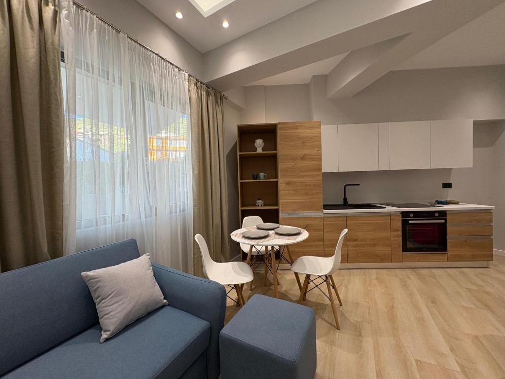 un salon avec un canapé bleu et une cuisine dans l'établissement glenz apartments, à Vlorë
