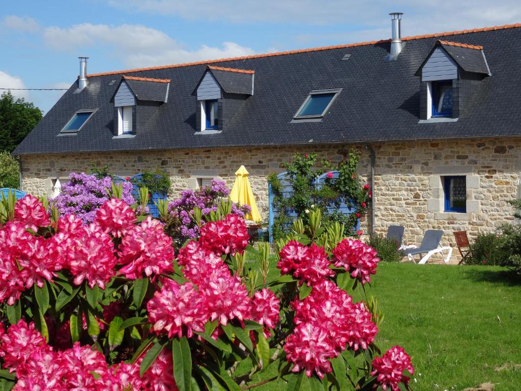 une maison avec des fleurs roses devant elle dans l'établissement Camping de la Plage de Cleut-Rouz, à Fouesnant