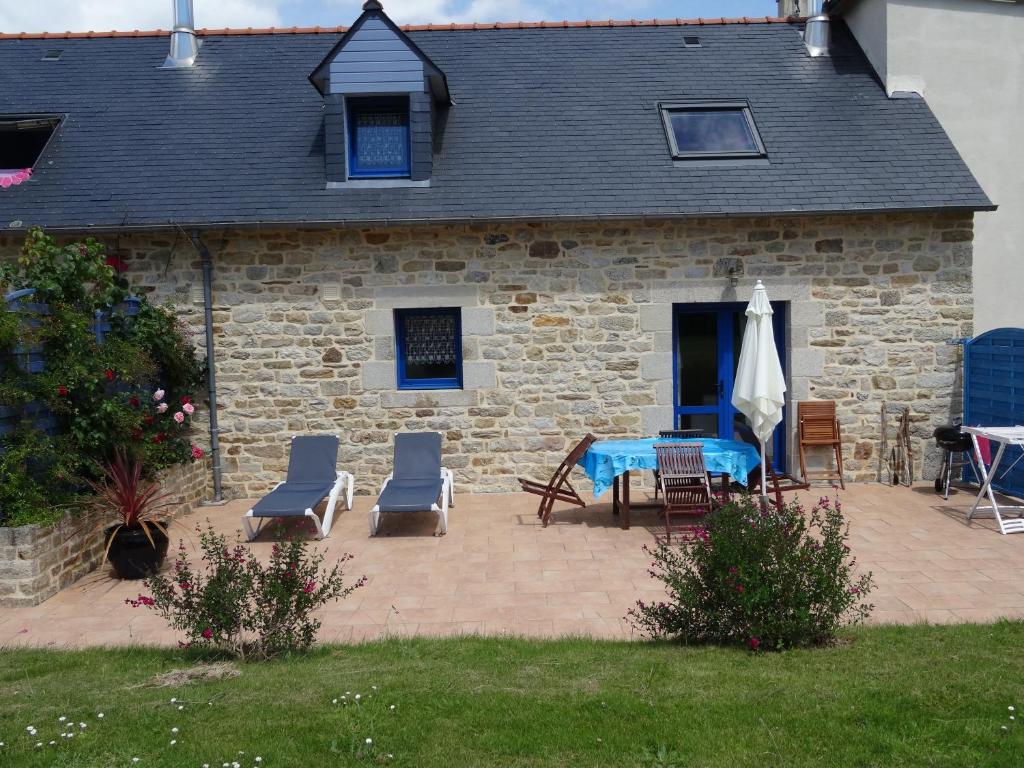 une maison avec un patio avec une table et des chaises dans l'établissement Camping de la Plage de Cleut-Rouz, à Fouesnant