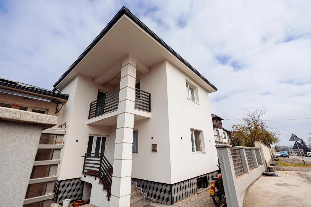 a white house with a black roof at Acasa La Lumei in Sighetu Marmaţiei