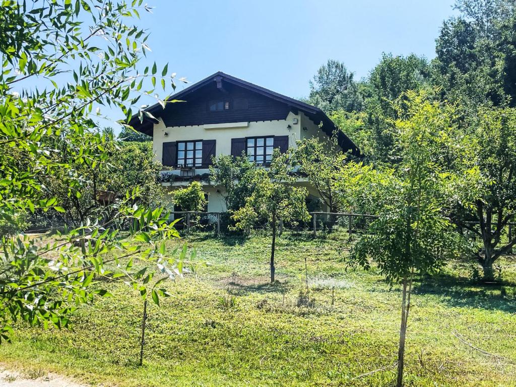 dom na polu z drzewami przed nim w obiekcie Holiday Home Del Respiro by Interhome w mieście Mongardino
