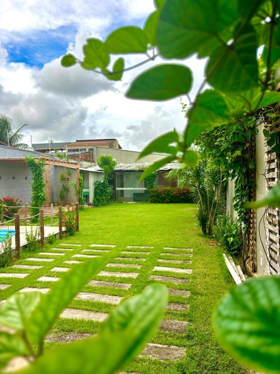 a garden with a lawn and some plants at Dunamis in São Gonçalo do Amarante