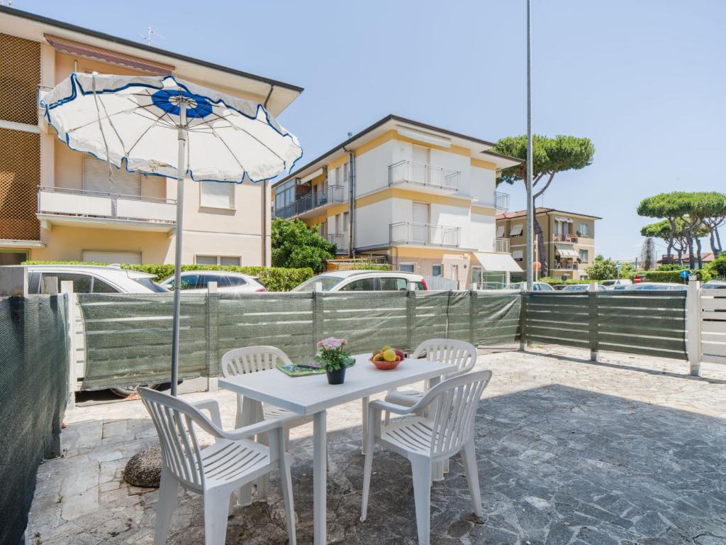 a white table with chairs and an umbrella at Apartment Appartamento Lara by Interhome in Lido di Camaiore