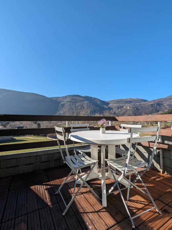 a table and chairs on a deck with a view at La Terrasse du Tarn in Ispagnac