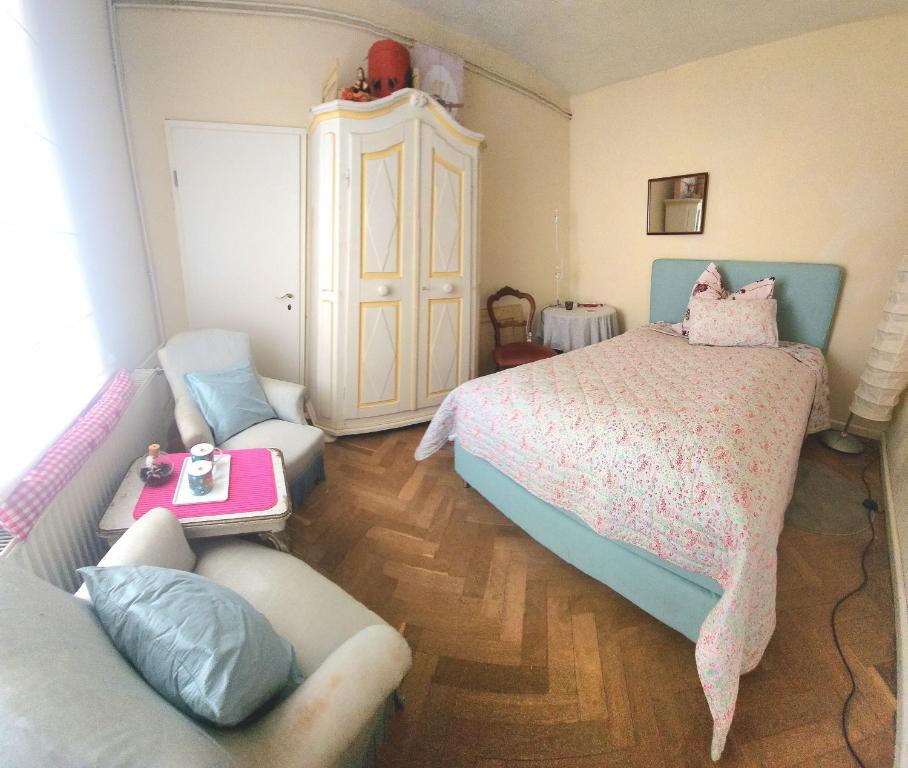 ein Schlafzimmer mit einem Bett, einer Couch und einem Sessel in der Unterkunft Cosy Cottage Rooms near Autobahn A2 & Hannover in Barsinghausen