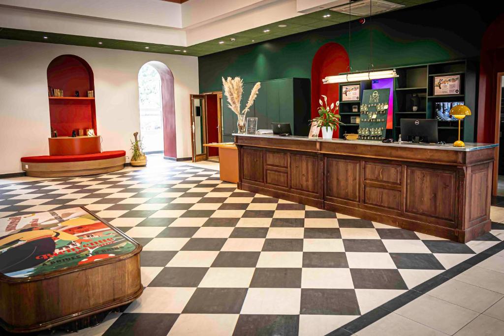 a restaurant with a counter and a checkered floor at B&B HOME Brides-les-Bains Les 3 Vallées in Brides-les-Bains