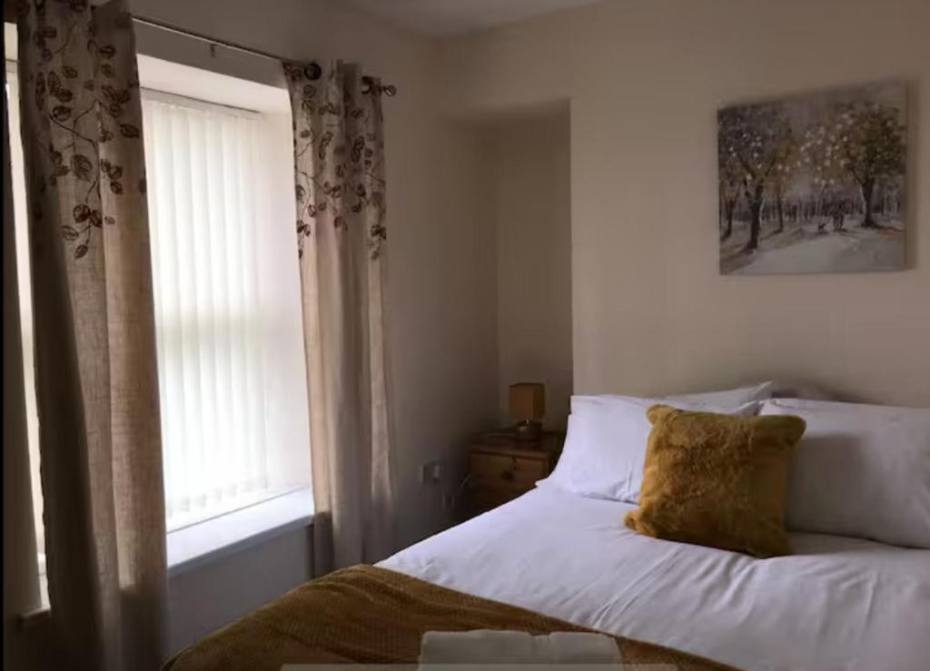a bedroom with a white bed with a window at 34 - Room 7 - Uplands in Swansea